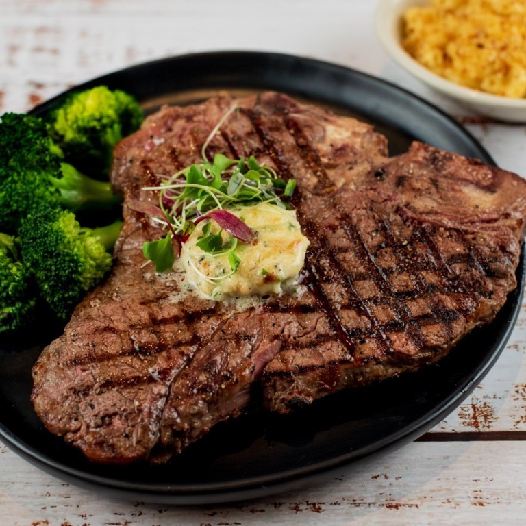 A bone-in strip off the broiler, crosshatched and finished with herb butter.
