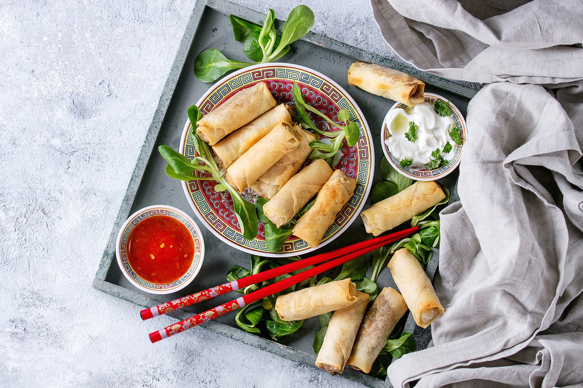 Golden spring rolls stacked on a serving tray